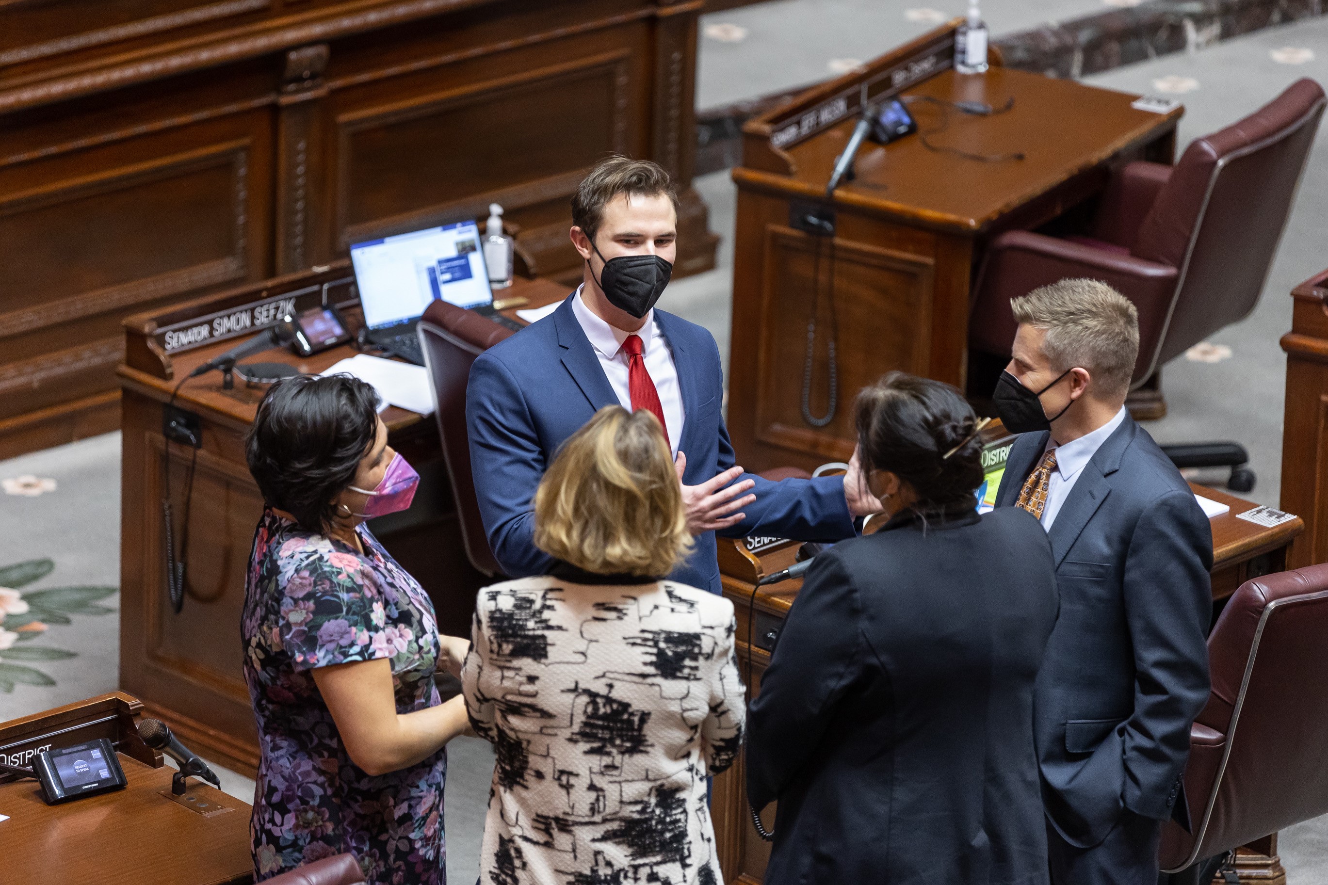 Sefzik speaking with other senators on the state senate floor.